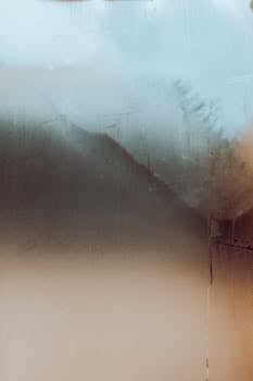 Misty and abstract view through a blurred glass window with water droplets.